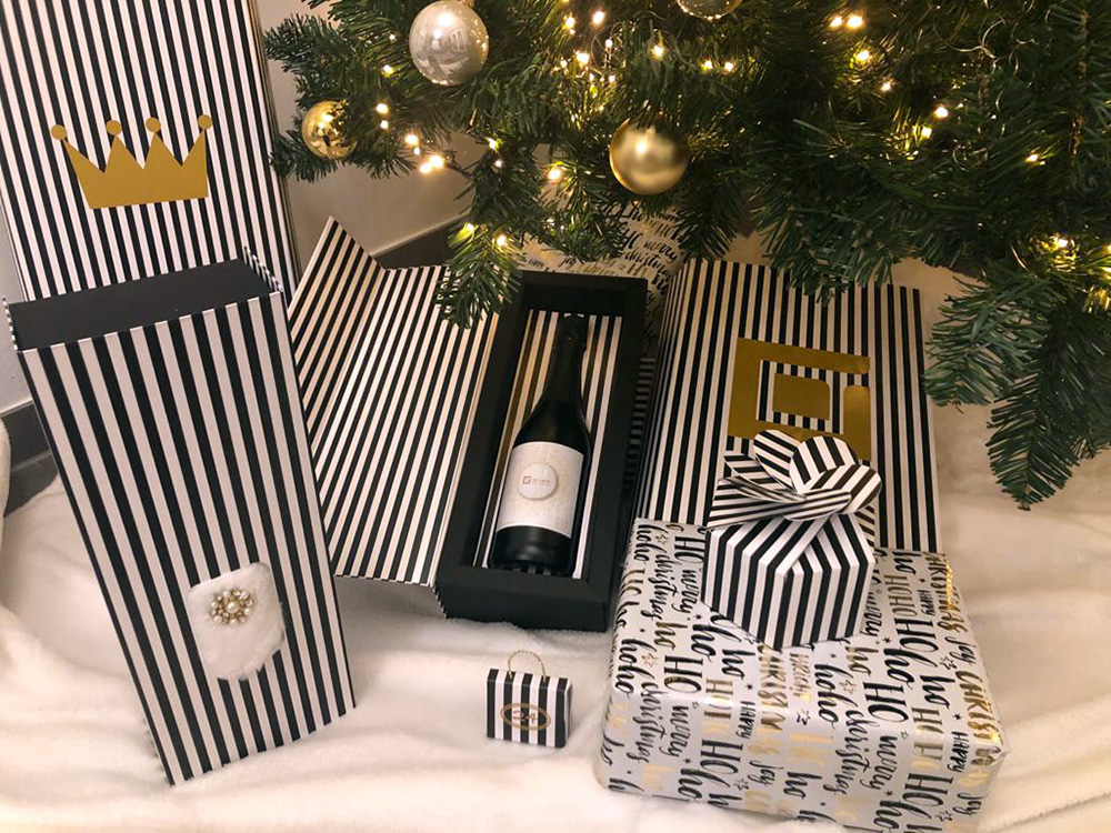 Weihnachtliche Pr&auml;sentverpackungen, Geschenkboxen und Verpackungen mit Streifendesign unter einem dekorierten Weihnachtsbaum